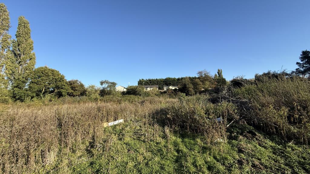 Lot: 42 - SITE WITH PLANNING FOR 10 HOUSES - External image of site from gate on main road